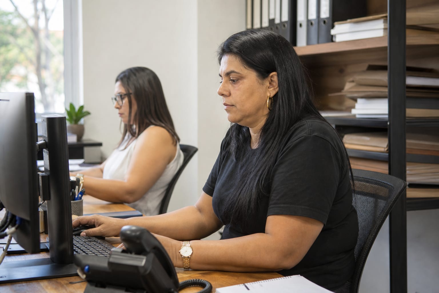 Equipe de administradora de condomínios analisa contratos e telas no escritório